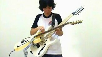 Играет на двух гитарах сразу - смотреть видео (1:39)